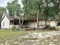 Charming single story home with a wooden deck and a large yard surrounded by mature trees at 25600 Se 152Nd Pl, Umatilla, FL 32784