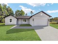 Charming single-story home featuring a lush green lawn and a two-car garage at 5 Willow Trl, Ocala, FL 34472
