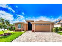 Beautiful single-story home featuring brick paved driveway and two-car garage with lovely tropical landscaping at 4577 Back Nine Dr, Winter Haven, FL 33884