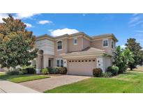 Two-story house with a three-car garage and manicured lawn at 318 Crescent Ridge Rd, Auburndale, FL 33823