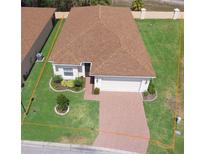 Charming single-story home with well-manicured lawn, brick driveway, and attached two-car garage at 2410 Salzburg Loop, Winter Haven, FL 33884