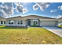 Charming single-story home features a well-manicured lawn, neutral color palette, and attached two car garage at 4039 Tullamore Ln, Auburndale, FL 33823