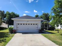 Charming single-story home with a well-manicured lawn, a two car garage, and lovely landscaping at 2158 Mirasol Dr, Winter Haven, FL 33881