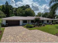 Charming one-story home featuring lush landscaping and a brick paver driveway at 3808 Gaines Dr, Winter Haven, FL 33884