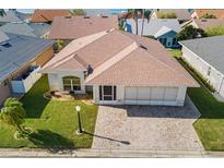 Beautiful single-story home featuring lush landscaping, brick driveway, and a two-car garage at 627 Watercrest Dr, Haines City, FL 33844