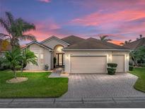 Charming home featuring a spacious three-car garage, lush landscaping, and a brick paved driveway at 4193 Stone Creek Loop, Lake Wales, FL 33859