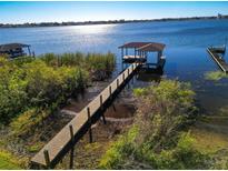 Picturesque view of a private boat dock extending into a tranquil lake with a covered pavilion at 4027 Island Lakes Dr, Winter Haven, FL 33881