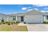 Charming single-story home with a well-manicured lawn, covered entry, and a two-car garage at 566 Valentina Ln, Auburndale, FL 33823