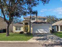 Two-story house with a white garage door and a well-maintained lawn at 1333 Rebecca Dr, Haines City, FL 33844