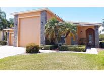 Charming single-story home featuring a stone-accented facade, well-manicured lawn, and mature palm trees at 4101 Limerick Dr, Lake Wales, FL 33859