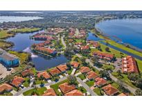 Community aerial view highlighting lakes, green spaces, and residences with terra cotta roofs at 802 Magnolia Pl, Winter Haven, FL 33884
