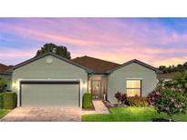 Well-maintained house with a landscaped front yard, neutral color scheme, and a two-car garage at 4076 Tralee Dr, Lake Wales, FL 33859