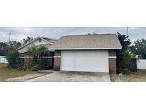 Brick house with attached garage, driveway, and landscaping at 6102 N Fork Ct, Lakeland, FL 33809