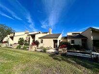 Light beige condo building with stone accents and landscaping at 19 Aspen Dr. # 19, Haines City, FL 33844