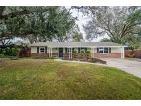 Ranch-style home with brick facade, landscaping, and driveway at 2104 John Arthur Way, Lakeland, FL 33803
