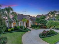 Stunning home exterior with circular driveway, lush landscaping, and elegant architectural details at 221 Mclean Pt, Winter Haven, FL 33884
