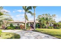 Beautiful single-story home with a well-maintained lawn, lush landscaping, and a circular driveway at 2428 Wildwood Ct, Winter Haven, FL 33884