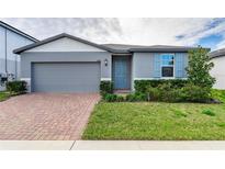Gray one-story house with gray garage door and blue front door at 3285 Weitzel Dr, Haines City, FL 33844