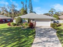 Single-story home with attached garage and well-manicured landscaping at 38 Grenewood Ln, Haines City, FL 33844