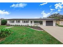 Charming ranch home with a white exterior, black accents, and well-manicured lawn at 5524 Meander Dr, Lake Wales, FL 33898