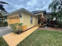 Single-story home with attached garage, landscaped lawn, and walkway at 1068 Stoney Creek Dr, Lakeland, FL 33811