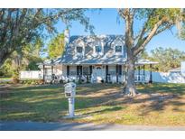 Charming two-story house with a wraparound porch and manicured lawn at 2238 Groveglen Ct, Lakeland, FL 33812
