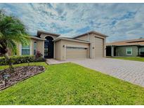 House exterior featuring a two-car garage and manicured lawn at 3834 Litchfield Loop, Lake Wales, FL 33859
