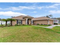Single-story home with landscaped lawn and a neutral color palette at 5378 Hidden Oaks Dr, Lakeland, FL 33811