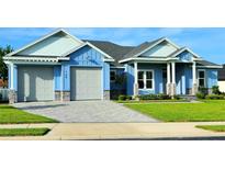 Beautiful two-story home with light blue exterior, gray stone accents, and a large driveway at 780 Waterfern Trail Dr, Auburndale, FL 33823