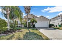 Two-story house with a white garage door and landscaped lawn at 1153 Legatto Loop, Dundee, FL 33838