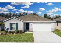 Single-story home with two-car garage and landscaping at 264 Spirit Landings Cir, Winter Haven, FL 33880