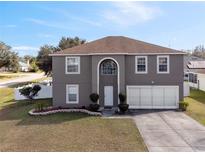Two-story house with gray siding, two-car garage, and landscaped lawn at 343 Drum Ct, Kissimmee, FL 34759