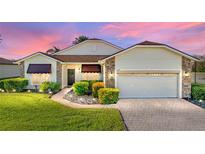 Attractive single-story home with landscaped yard, paver driveway, and two-car garage at 4195 Muirfield Loop, Lake Wales, FL 33859