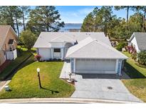 Single-story home with lake view and spacious driveway at 462 Sweetwater Way, Haines City, FL 33844