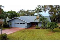 House exterior boasts a gray roof, attached garage, and a well-manicured lawn at 952 N Heron Cir, Winter Haven, FL 33884