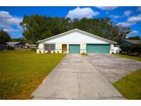 Charming single-story home features a 2-car garage, well-maintained lawn, and mature trees at 110 Lake Mattie Rd, Auburndale, FL 33823