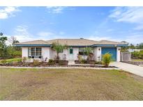 Single-story home with landscaped yard and attached garage at 2330 Park Ave, Indian Lake Estates, FL 33855