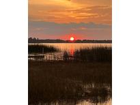Stunning sunset over lake with tall grass in foreground at 2400 Crump Rd, Winter Haven, FL 33881