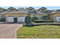 Tan two-story home with two-car garage and landscaped yard at 2739 Rutledge Ct, Winter Haven, FL 33884