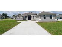 Charming single-Gathering home with stone accents, light gray paint, attached garage, and a large front yard at 304 Denna Ln, Auburndale, FL 33823