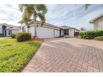 Brick paved driveway leads to charming house with palm tree and well-manicured lawn at 3445 Raleigh Dr, Winter Haven, FL 33884