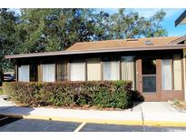 Condo exterior featuring a brown roof and landscaped hedges at 40 Kimberly Ct, Winter Haven, FL 33880