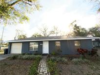 Ranch style home with gray exterior, attached garage, and landscaped yard at 4089 Lana Dr, Lakeland, FL 33813