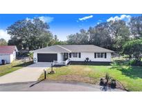 White house with dark brown garage door, white picket fence, and well-maintained lawn at 428 Durrell Ct, Winter Haven, FL 33884