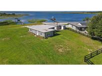 Aerial view of waterfront home with private dock and expansive lake views at 557 Thornburg Rd, Babson Park, FL 33827