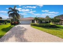 Charming single Gathering home featuring a paver driveway and mature landscaping at 768 Canberra Rd, Winter Haven, FL 33884