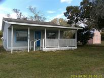 Gray house with white porch and a pink shed in the backyard at 8150 State Road 60 E, Bartow, FL 33830