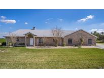 Sprawling brick ranch-style home with mature landscaping and well manicured lawn at 1815 Adams Barn Rd, Lake Alfred, FL 33850