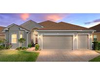 Charming single-story home with a well-manicured lawn, brick driveway, and a two-car garage at 4033 Phoenician Way, Winter Haven, FL 33884