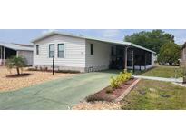 Charming single-story home featuring a covered carport, screened porch, and well-maintained landscaping at 6059 Southern Oaks Se Dr, Winter Haven, FL 33884